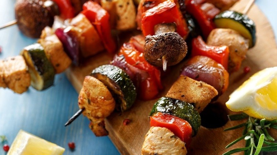 Sommerlige grillspyd med kylling ligger p et skrebrt, klar til at blive serveret.